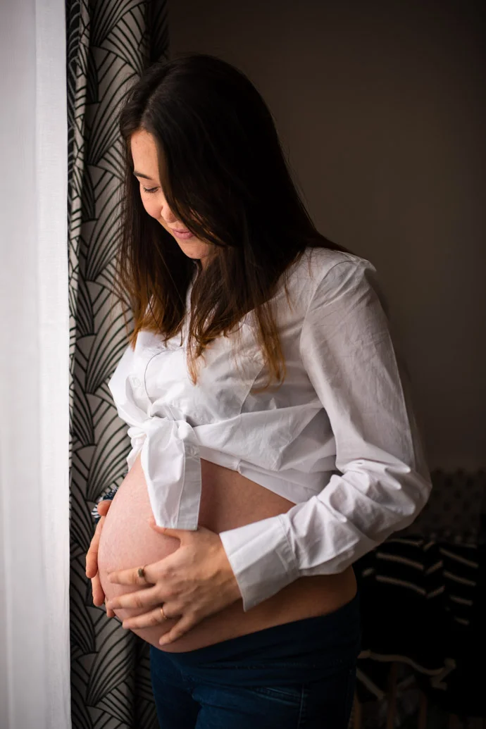 séance photo grossesse en Essonne, jolie future maman qui contemple son ventre de femme enceinte