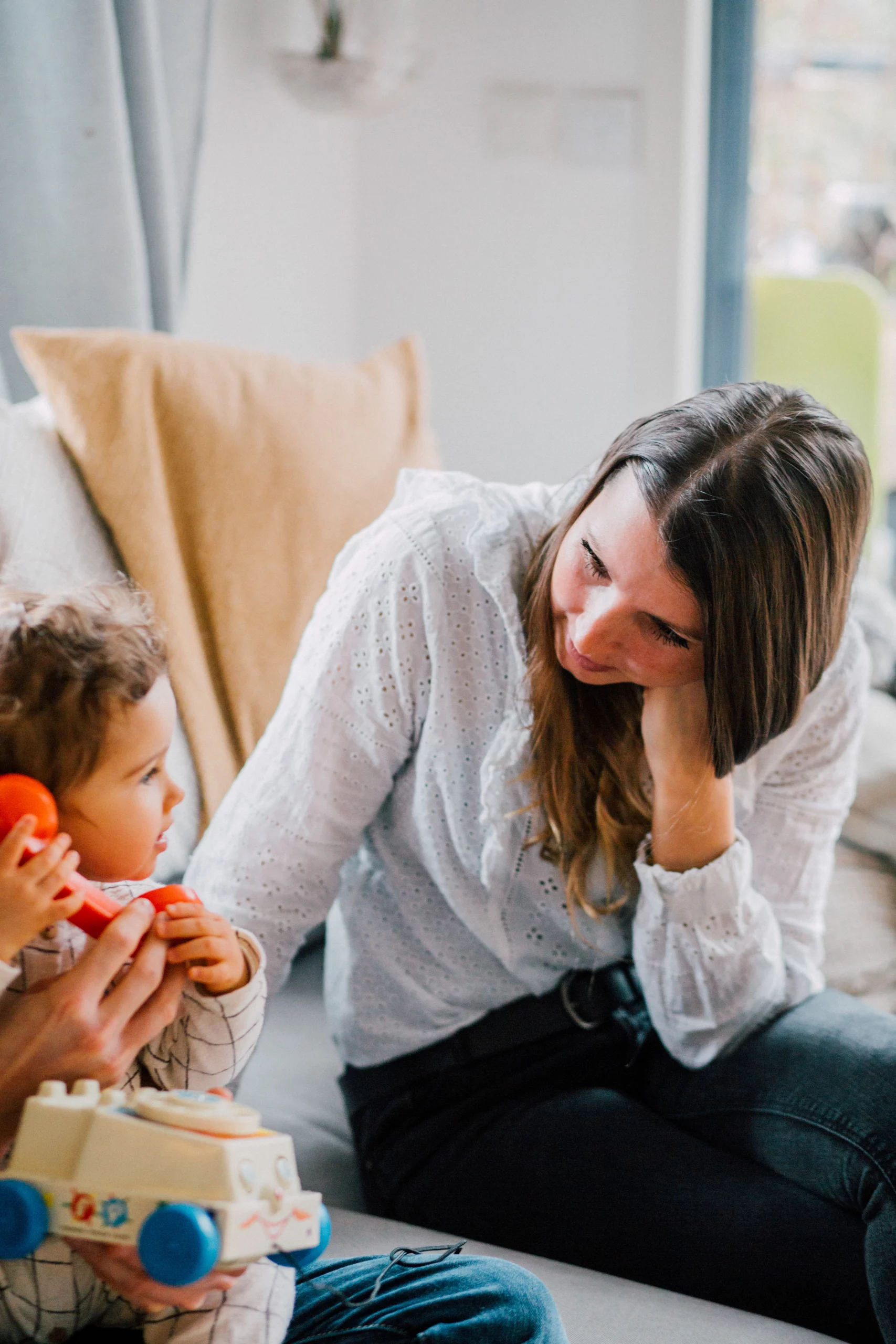 maman photographe qui observe son enfant en train de jouer lors d'une séance photo à domicile en Ile de France