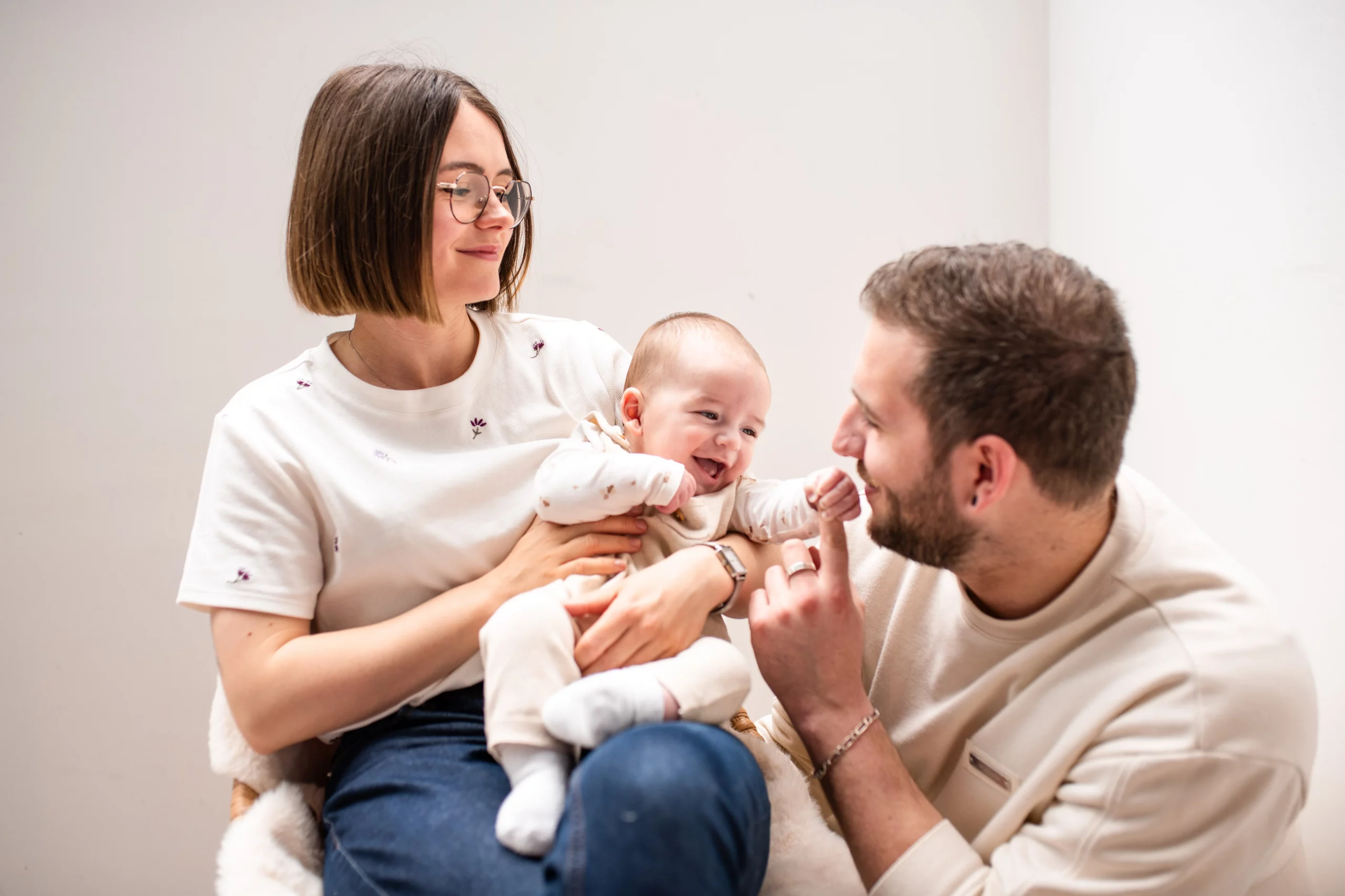 bébé rigolant avec ses parents lors d'une séance photo en studio