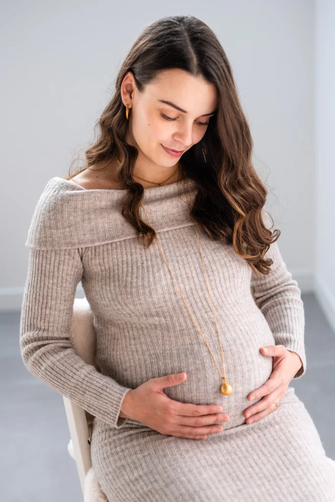 future maman caressant son ventre rond lors d'une séance photo grossesse