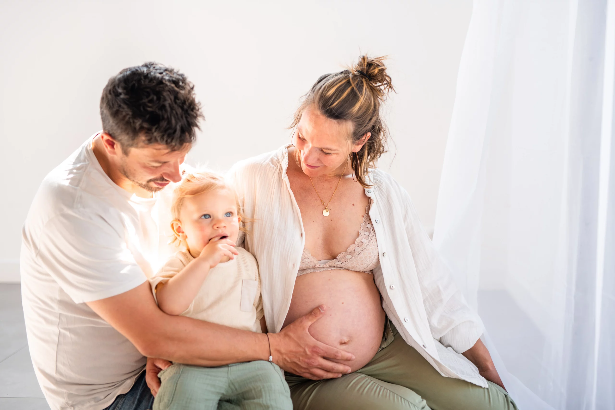 Studio photo essonne, petit garçon souriant lors d'une séance photo grossesse avec ses parents