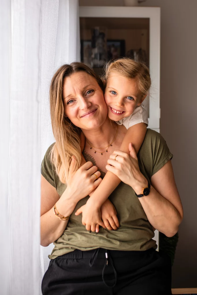 petite fille sur le dos de sa maman, souriantes, lors d'une séance photo famille
