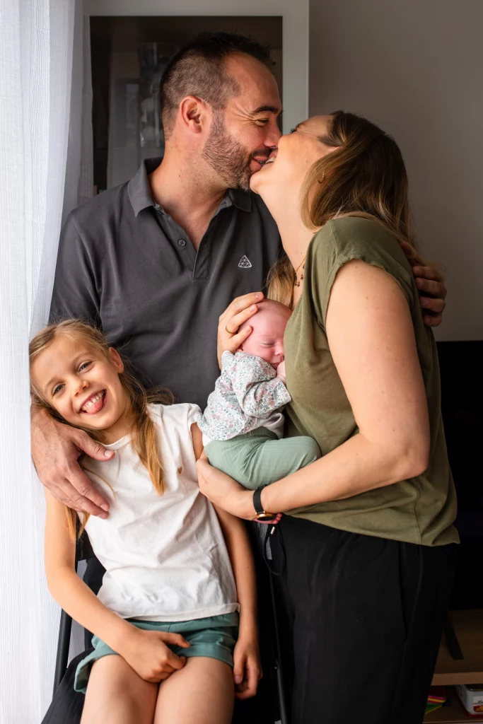 portrait d'une famille souriante lors d'une séance photo naissance