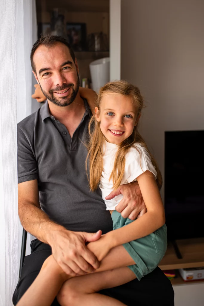 petite fille dans les bras de son papa lors d'une séance photo famille