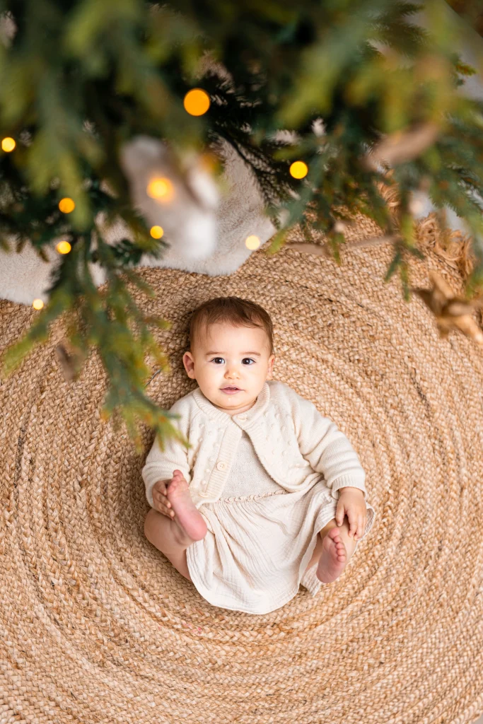 portrait d'une bébé au pied du sapin de noël