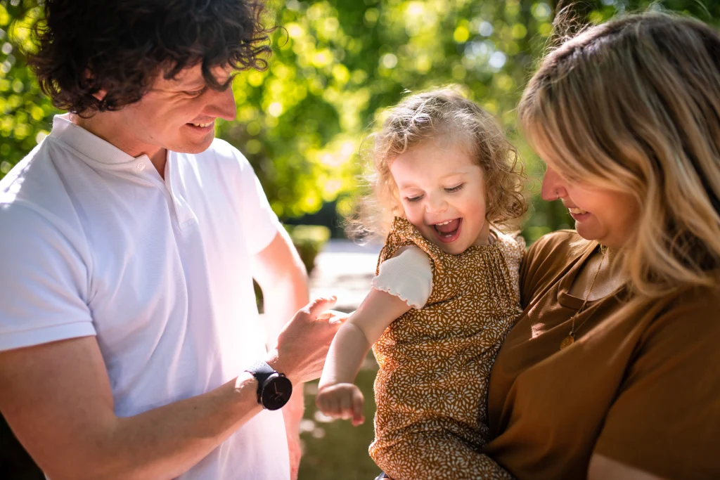 petite fille souriante dans les bras de sa maman