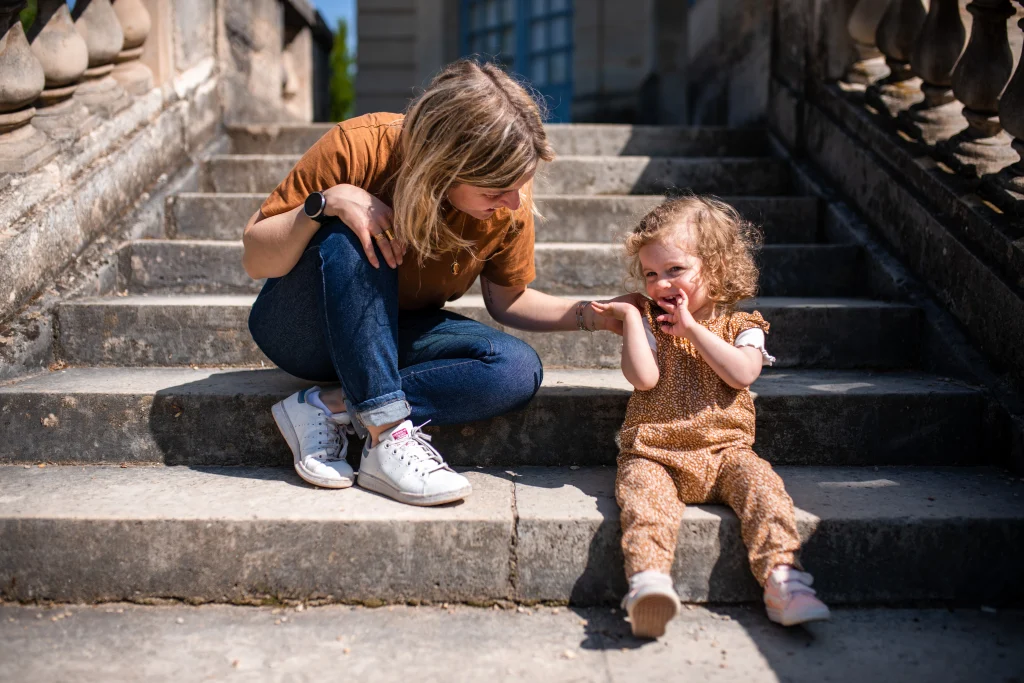 petite fille assise sur les marches d'un escalier avec sa maman