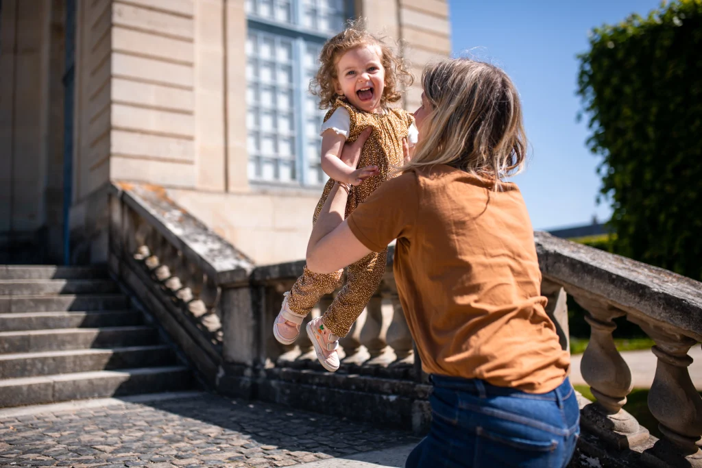 petite fille qui saute dans les bras de sa maman lors d'une séance photo